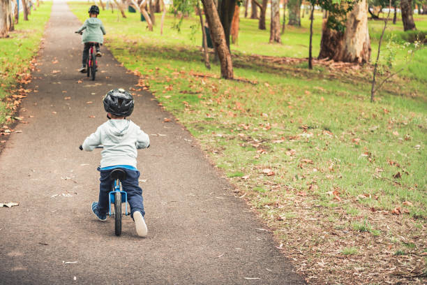 kids riding bicycles - footpath small green white imagens e fotografias de stock