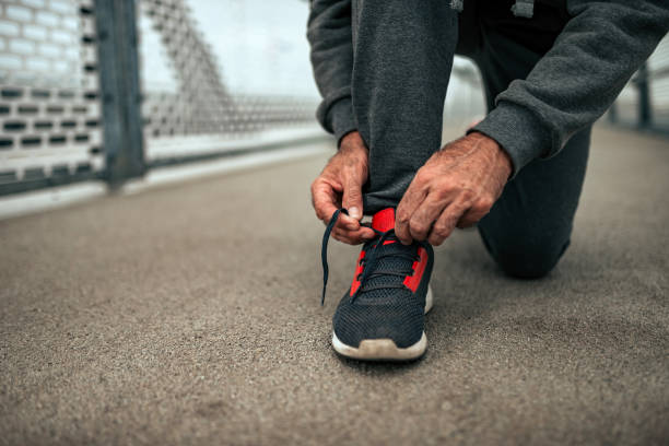 istock Senior man tying shoelaces before a run. Close-up. 1069581144