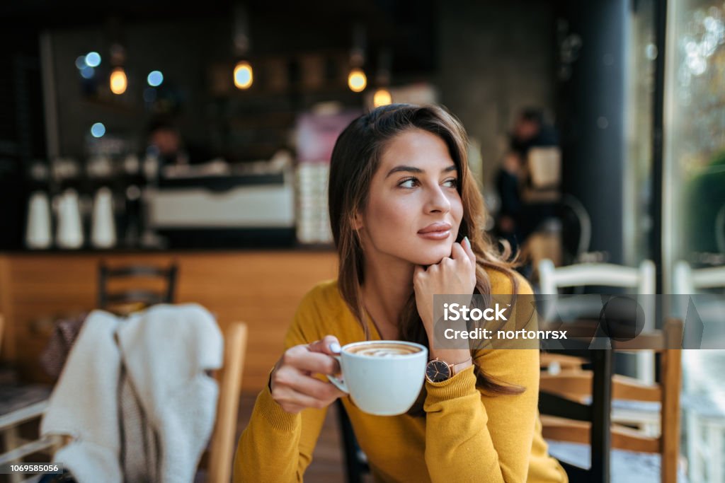 Elegante joven bebiendo café en la cafetería, mirando lejos. - Foto de stock de Café - Bebida libre de derechos