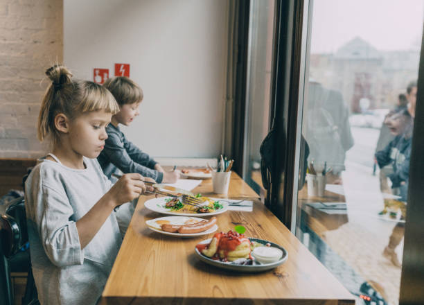 istock Little girl and boy sitting in cafe 1069586518