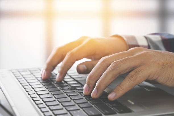 istock Man hands typing on a laptop keyboard on a desk, Website developer, people and technology concept 1069591532