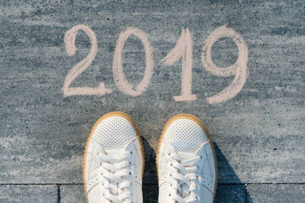 istock Female feet with text 2019 written on asphalt 1069591706
