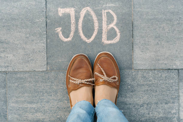 istock Female feet with text job written on grey sidewalk 1069592114