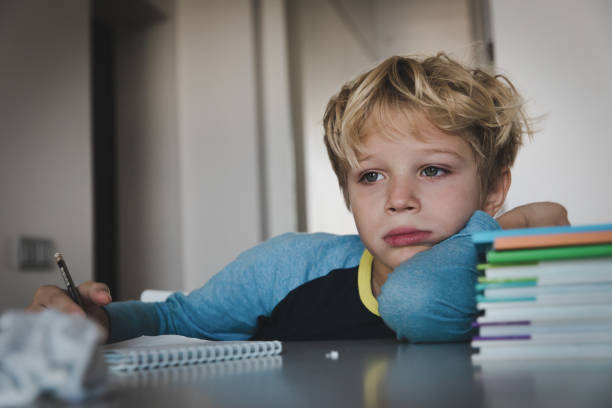 little boy tired stressed of reading, doing homework stock photo
