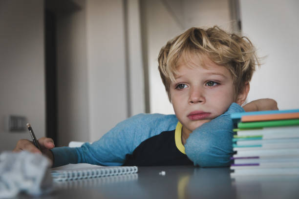 little boy tired stressed of reading, doing homework little boy tired exhausted stressed of reading, doing homework child sadness stock pictures, royalty-free photos & images