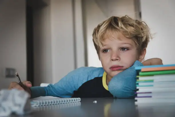 Photo of little boy tired stressed of reading, doing homework