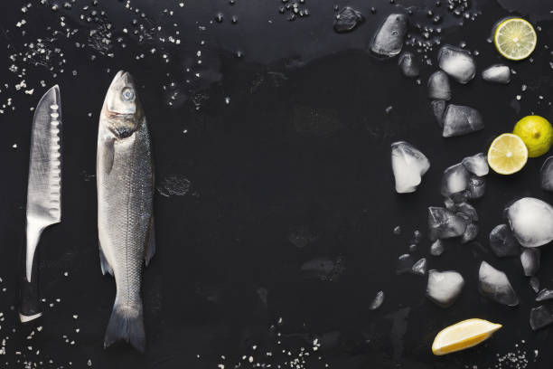 istock Fresh sea bass with ice at black background 1069595168