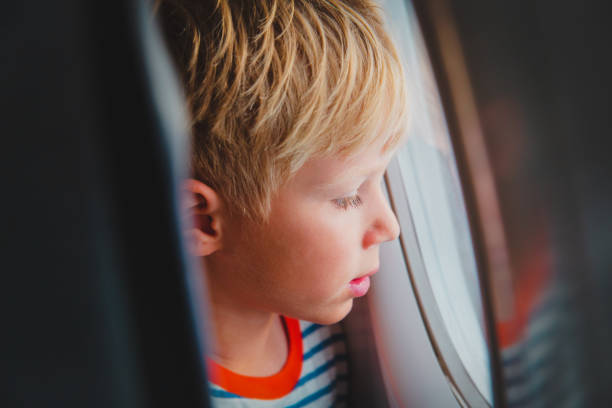 istock little boy travel by plane looking through window 1069595664