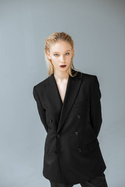 istock young stylish woman posing in black suit isolated on grey 1069598080