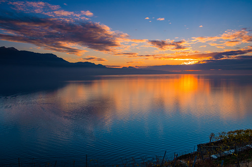 Beautiful colorful sunset in the autumn above the French Alps and  Lake Geneva where the colors and clouds reflect beautifully.