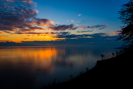 Beautiful colorful sunset in the autumn above the French Alps and  Lake Geneva where the colors and clouds reflect beautifully.