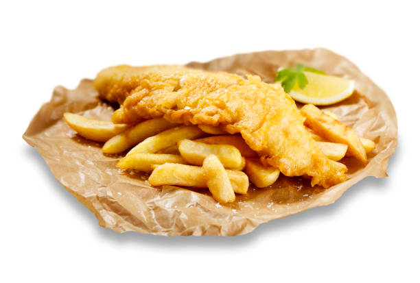 Fish and chips, in brown paper Isolated images of fish and chips, in brown paper, with a wedge of lemon. haddock stock pictures, royalty-free photos & images