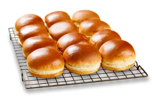 Isolated image of rows of brioch buns cooling on a wire tray.
