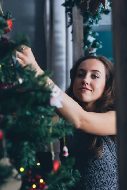 istock Beautiful girl arranges christmas tree. 1069602734