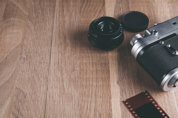 istock Old camera and lens on wooden table. The view from the top. Space for text or design 1069603554