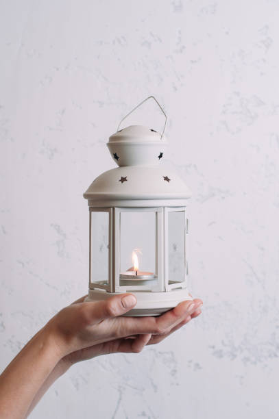 istock Woman holding a Christmas lantern on a white wall background 1069603712