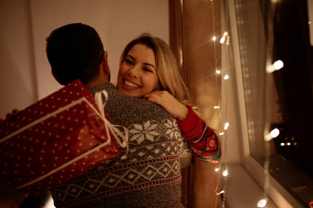 istock Couple sharing Christmas gifts at home 1069603986