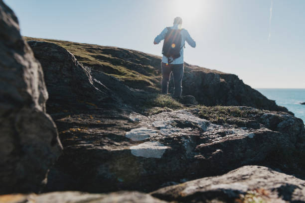 istock de-focused man Walking the Cornish Coast in the bright Autumn sunshine. 1069606946