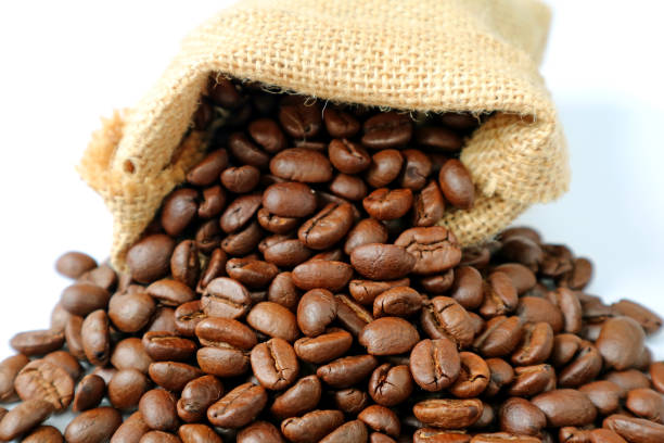 バーラップ袋から散在しているコーヒー豆の焙煎のヒープ - coffee bean cafe burlap sack burlap ストックフォトと画像