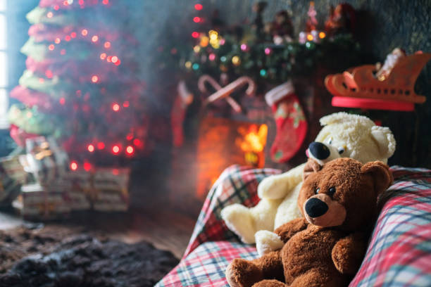 istock Teddy Bears Sits on Sofa near Christmas Tree and Fireplace 1069609230