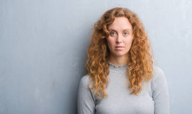 istock Young redhead woman over grey grunge wall with a confident expression on smart face thinking serious 1069616962