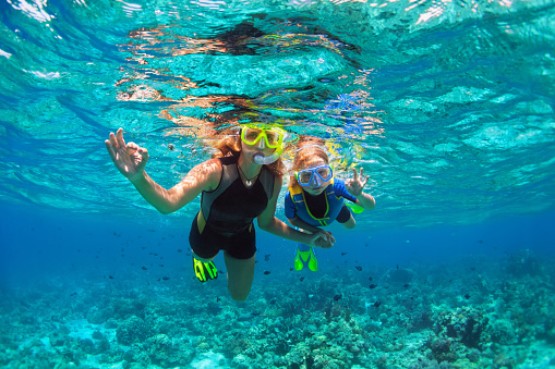Madre, niños en snorkel mascara buceo bajo el agua con peces tropicales photo