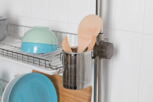 istock Clean dishes drying on metal dish rack on light background. Kitchen utensils and dishware on wooden shelf. Kitchen interior background.Text space. 1069622456