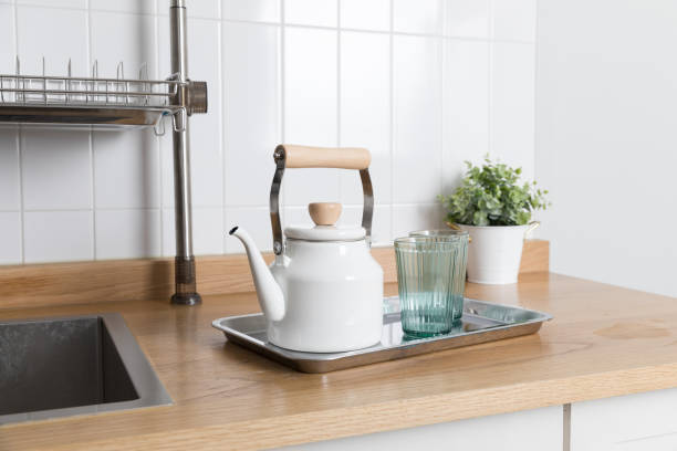 istock Clean dishes drying on metal dish rack on light background. Kitchen utensils and dishware on wooden shelf. Kitchen interior background.Text space. 1069624760