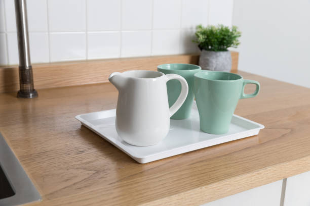 istock Clean dishes drying on metal dish rack on light background. Kitchen utensils and dishware on wooden shelf. Kitchen interior background.Text space. 1069624854