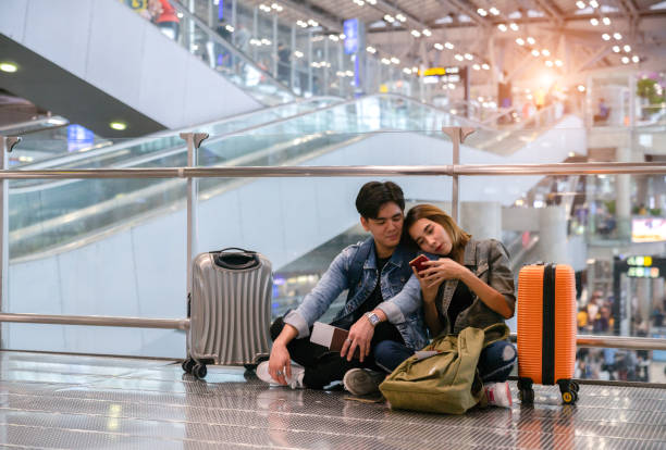 Asian couple wait boarding at the international airport stock photo
