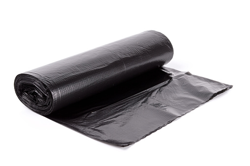 Black roll of plastic garbage bags isolated on white background