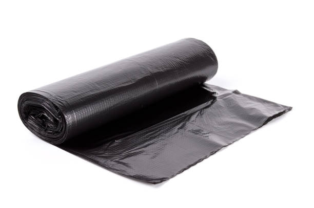 black roll of plastic garbage bags isolated on white background - bag garbage bag plastic black imagens e fotografias de stock