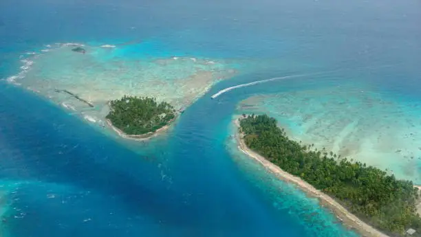 Aerial view of tropical islet with lagoon and channel, Avatoru pass, atoll of Rangiroa, Tuamotu archipelago, French Polynesia