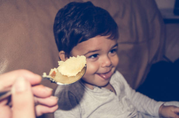 baby boy refusing to eat polenta with funny face and tongue out