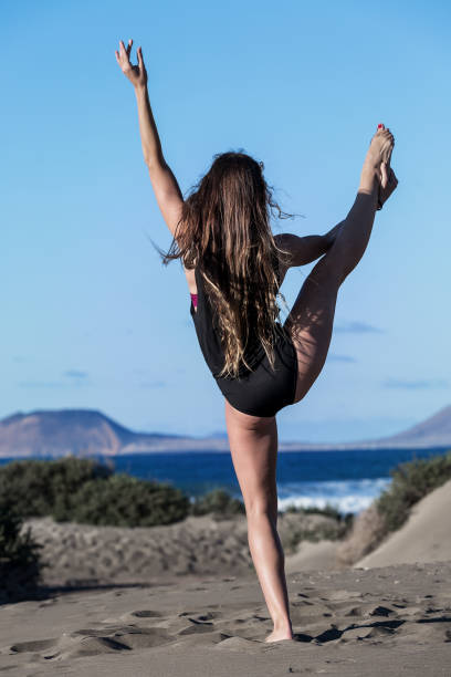 mujer pies descalza haciendo yoga en la playa - long hair rear view brown hair the human body fotografías e imágenes de stock
