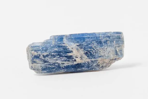 Ore kyanite on white background, is a typically blue silicate mineral, commonly found in aluminium-rich metamorphic pegmatites and/or sedimentary rock.