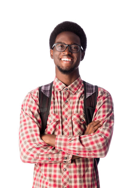 A young black man standing with his arms crossed, looking at the camera and smiling.
