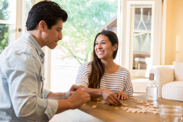 istock Married couple organize strategize during word game at home 1069669048
