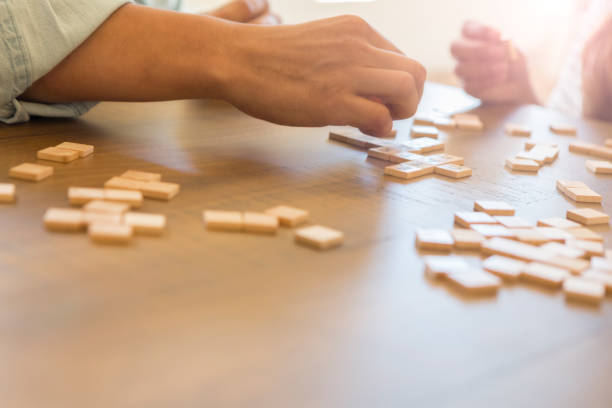 Unrecognizable couple organize word game tiles together