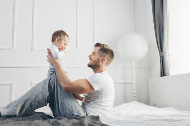 istock Happy father with his son playing at home on the bed 1069672678