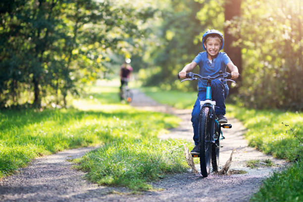 istock Little boy riding bike through puddle 1069673926