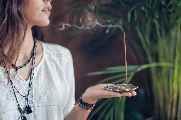 Beautiful mindfulness young girl relaxing and enjoying incense stick after yoga class.