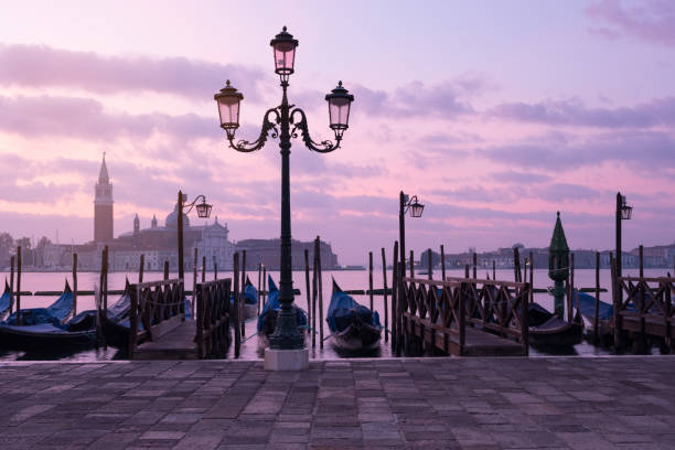 istock Venice classic sunrise view with gondolas on the waves 1069679110
