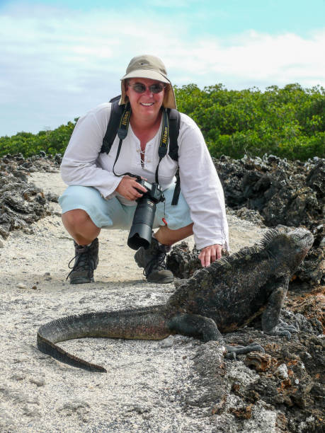 istock A woman photographer and a Marine iguana 1069679310