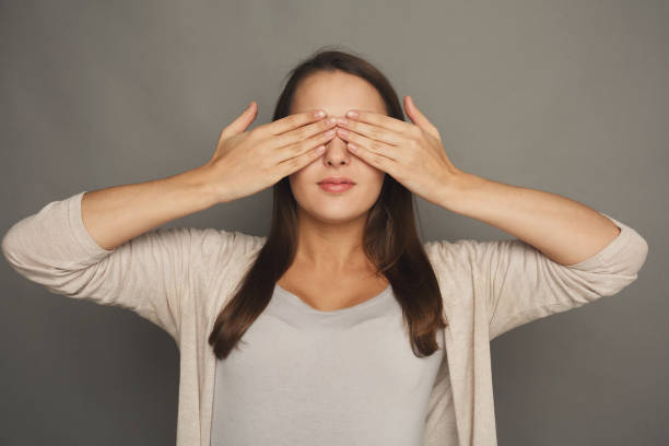 istock Scared woman covering eyes with hands, see no evil 1069682720