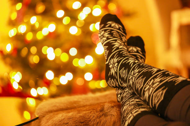 Cozy knitted socks peek out from beneath soft blankets, creating a tender scene of comfort and security. The warmth of home and the gentle textures evoke a feeling of protection and peace, a quiet refuge from the world. Copy space for text, high angle view - Autumn, lifestyle
