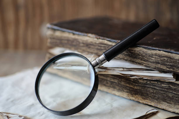 istock Old books on a wooden table and magnifier 1069685378