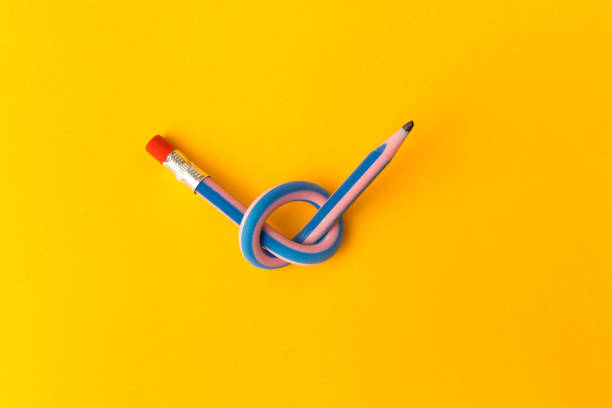 crayon de flexible sur fond jaune. crayons pliés deux couleurs. concept d’affaires - flexibility photos et images de collection