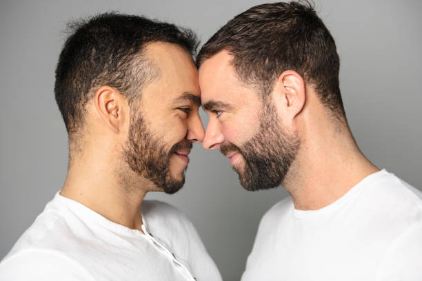 istock homosexual couple over a white background on studio 1069688792