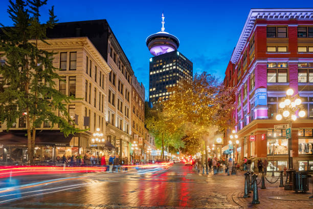 Water street in Gastown and Vancouver Lookout in downtown Vancouver Canada Long exposure stock photograph of Water street with the steam clock and the Vancouver Lookout in the background in Gastown, downtown Vancouver, British Columbia, Canada at twilight. vancouver canada stock pictures, royalty-free photos & images